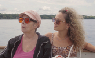 deux femmes assises cote à cote regardant à gauche devant un paysage de lac