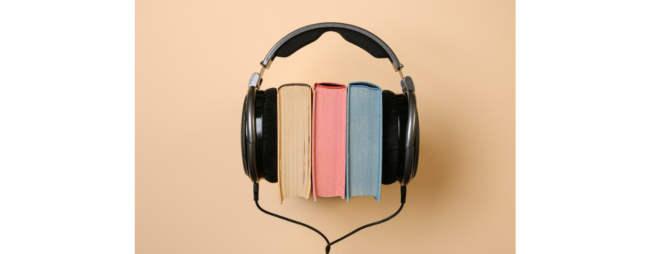 casque audio posé autour de trois livres sur fond beige