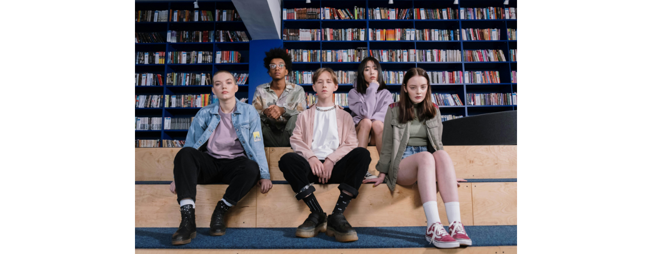 groupe de jeunes assis sur une estrade et regardant le spectateur