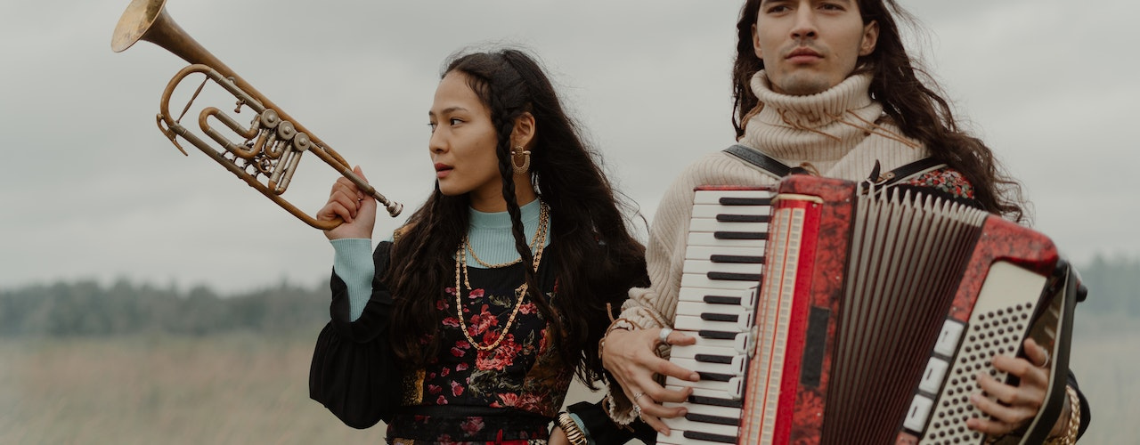 femme et homme dans un champs avec des instruments de musique