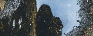 reflet d'une jeune femme dans une flaque d'eau